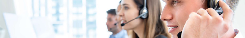 Customer service representatives wearing headsets in a call center.